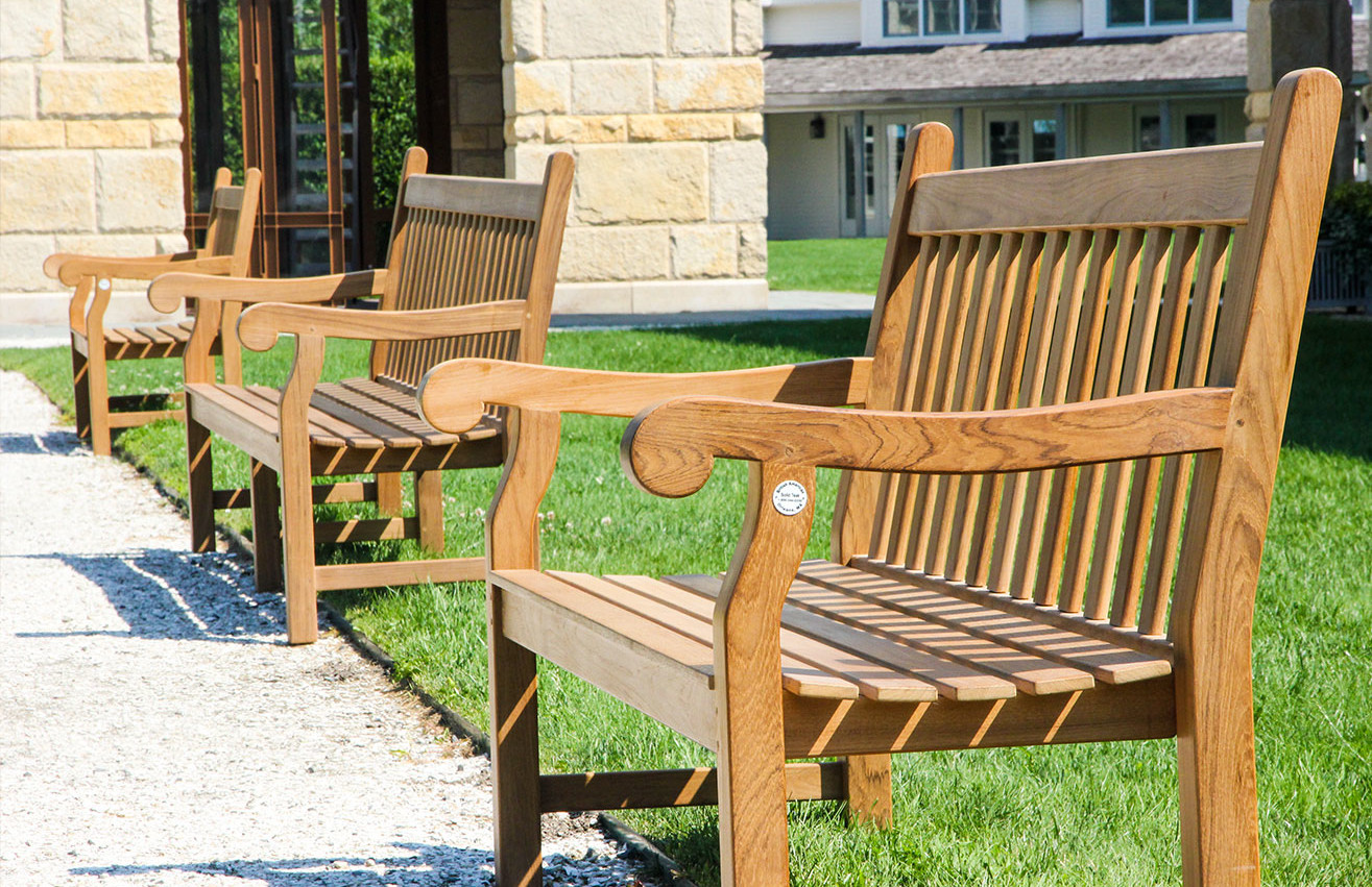 Medway high-quality teak bench shown outdoor on college campus