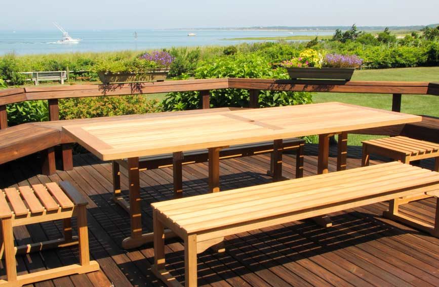 High-quality teak table and bench set shown on outdoor deck overlooking ocean